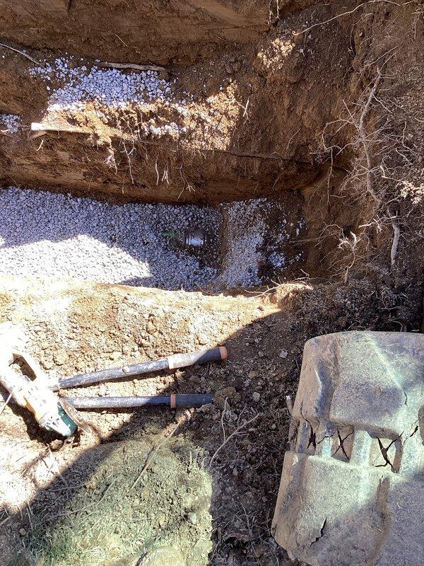 Completed full sewer lateral replacement involving exterior and interior main drain line rehabilitation. Excavated front yard and removed approximately 27'-30' of deteriorated clay piping from house to near road, replacing with new PVC pipe. Installed new riser pipe and cleanout assembly in front of house, backfilled excavation with dirt. Inside basement, jackhammered concrete floor to expose main drain line, removed old cast iron piping and replaced with new PVC. Tied new line into existing PVC main stack and installed additional cleanout for future access. Properly sloped all drainage lines to ensure adequate flow, backfilled interior excavation with dirt, and poured rough concrete patch to restore basement floor. Obtained required exterior sewer lateral replacement permit and coordinated inspection scheduling.