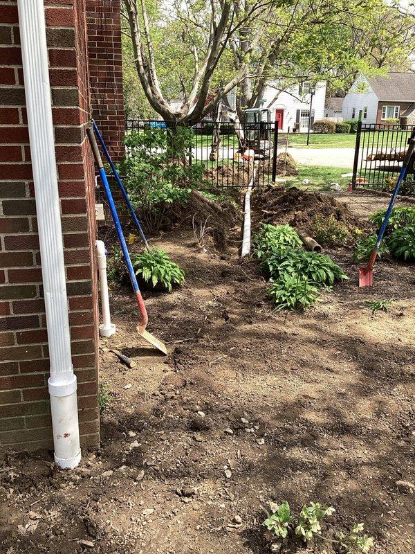 Installed approximately 60 feet of Schedule 35 PVC drainage pipe from the rear left corner of the residence to the street, terminating with a pop-up emitter. Excavated trench through front lawn to accommodate new drainage line. Modified existing sump pump discharge by cutting the 1-1/2" line after the existing 90-degree elbow, installed additional 90-degree fitting, and redirected discharge into a dedicated 4" riser for improved drainage performance. Backfilled trench upon completion of installation.