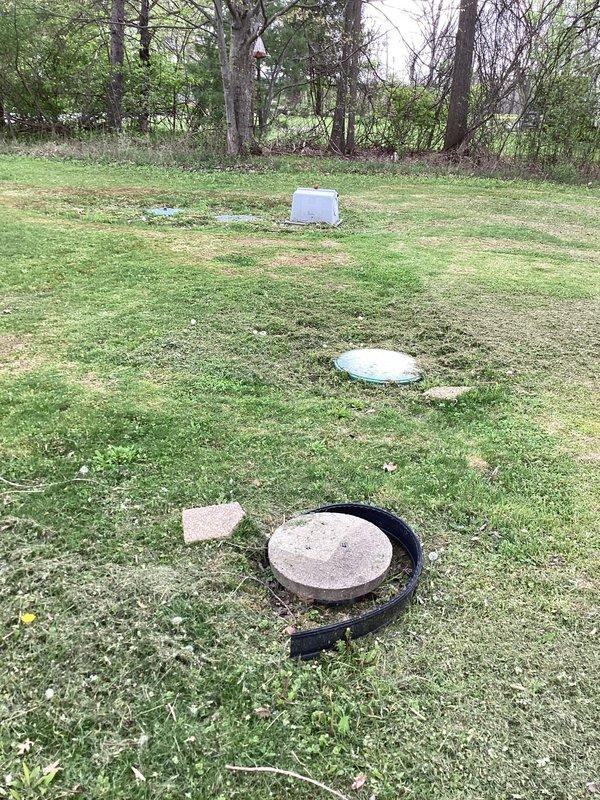 Conducted on-site estimate for new construction plumbing connection where municipal sewer line has been installed and requires hookup to residence with existing septic system removal. Assessed property conditions, located existing septic tank access points and new sewer connection point marked in lawn, and documented site conditions through photographic documentation to develop scope of work for transitioning from septic to municipal sewer service.