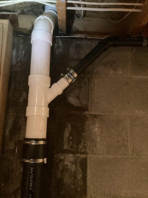 Responded to main drain line concern at 30-year-old residential property. Performed video camera inspection of main sewer line from basement cleanout to identify blockage or structural issues in the line going into ground. Inspection revealed aging cast iron and PVC drain assembly with rubber coupling connections at the main stack. Accessed plumbing through existing wall opening showing vertical drain configuration with proper venting. Documented current condition of drainage system including concrete foundation penetration point and basement piping layout. Main drain assembly showed typical age-related wear but remained structurally sound with no immediate failures detected in visible sections.