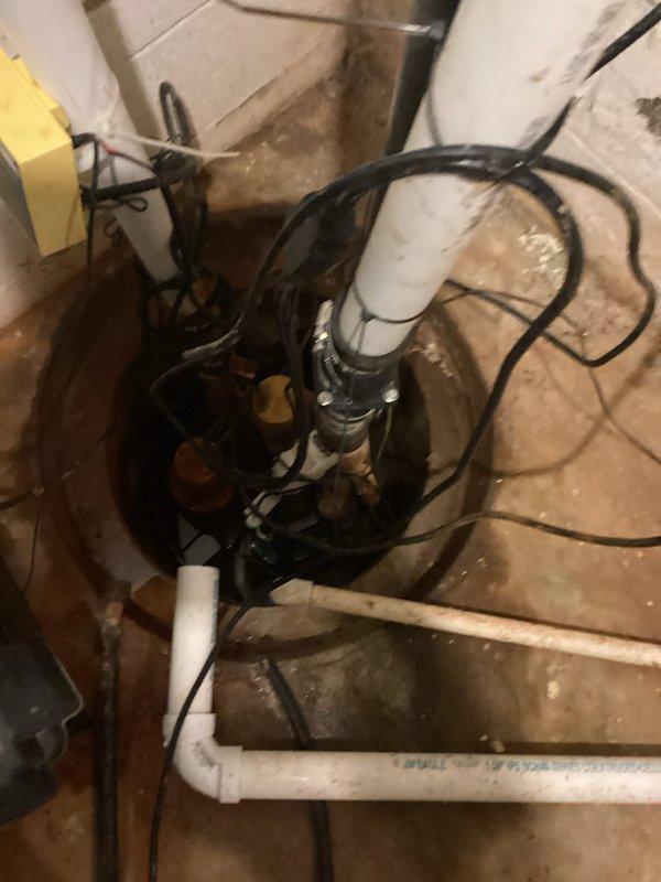 Responded to service call for sump pump leaking from bottom during cycle operation. Upon inspection, identified active leak at base of pump housing within sump pit. Assessed pump installation, discharge piping connections, and check valve assembly for proper operation and seal integrity. Documented existing conditions showing mineral deposits and water staining on pit walls, indicating previous moisture issues. Evaluated electrical connections, pump controller functionality, and PVC discharge line configuration to determine source of leak and recommend appropriate repair or replacement options to prevent continued water intrusion during pump cycling.