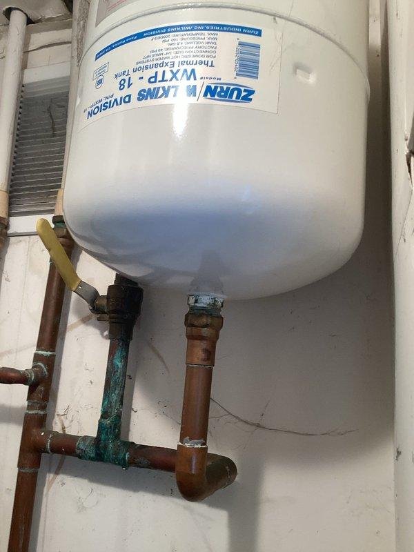Responded to utility room water leak caused by failing main ball valve feeding the unit. Replaced corroded brass ball valve showing significant deterioration and green patina buildup on copper connections. Installed new Zurn WXTP-18 thermal expansion tank to replace failing unit, connecting to existing copper supply lines with proper shut-off valves and fittings to ensure system integrity and prevent future pressure-related issues.