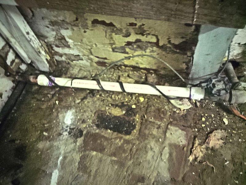 Responded to vacant unit requiring meter horn installation to facilitate water service restoration by municipal utility. Upon arrival, accessed property via lockbox and located water meter assembly in deteriorated basement/crawl space area showing extensive water damage and long-term neglect. 

Installed new meter horn on existing water meter per code requirements to allow city water department to restore service to the property. Completed installation using appropriate fittings and connections to integrate with existing white PVC supply piping and corroded gate valve assembly. Verified proper alignment and secure mounting of meter horn component to meet municipal inspection standards for service reconnection.