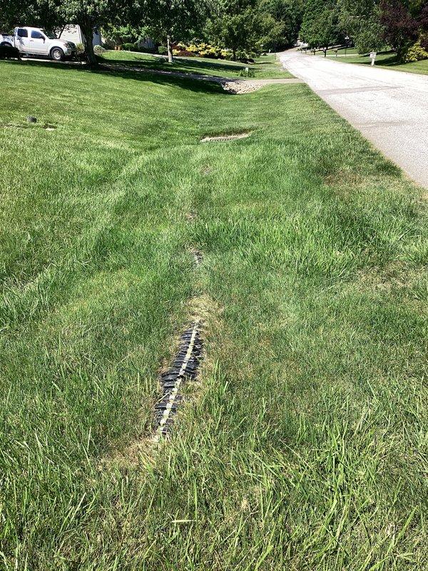 Responded to service call for repair of existing underground drainage system connected to gutter downspouts at 45-year-old residential property. Inspected linear drainage grate installed in front lawn area and assessed underground drainage lines for blockages, deterioration, or structural failure common in aging systems. Performed necessary repairs to restore proper water flow from gutters through underground drainage system, ensuring adequate runoff management away from foundation and preventing water accumulation near building structure.