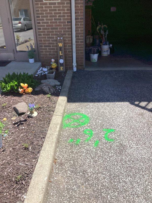Responded to water intrusion issue in garage. Upon inspection, identified downspout drain as source of water infiltration rather than door entry. Marked underground utility locations with spray paint indicators on driveway and sidewalk areas in preparation for drain line investigation and potential excavation work to resolve groundwater drainage problem.