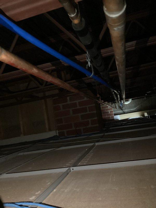Completed installation of 1" Wilkins backflow prevention device in basement plumbing system. Modified existing piping configuration to accommodate backflow preventer and added shut-off valve for system isolation. Routed new drain line as specified. Wall opening created for access; drywall restoration to be completed by property owner. Performed vacuum extraction and mechanical snaking of trough drain line to discharge pit to clear obstruction and restore proper drainage flow. Backflow device testing completed per regulatory requirements to ensure proper operation and compliance.