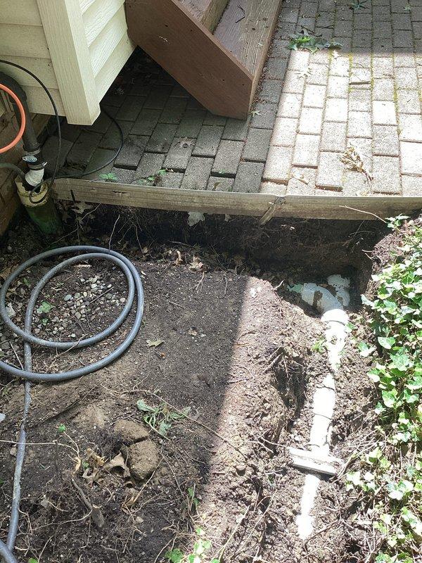 Excavated and exposed damaged section of underground drainage line beneath deck area. Removed approximately 5 feet of deteriorated pipe and replaced with Schedule 35 PVC piping, including proper fitting connections. Performed video camera inspection of downstream drainage system to verify pipe integrity and confirm no additional breaks or damage beyond repair area. Backfilled excavation upon completion of work.