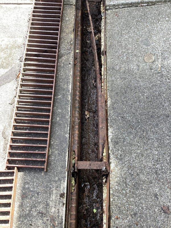 Responded to drainage concerns regarding unlevel concrete and sinking French drain system in front of garage. Cleaned out accumulated organic debris, sediment, and decomposed material from the driveway drainage channel and metal grate system. Performed visual scope inspection of drain lines entering and exiting the channel to verify proper water flow and operational functionality, confirming drainage system is clear and functioning as designed.
