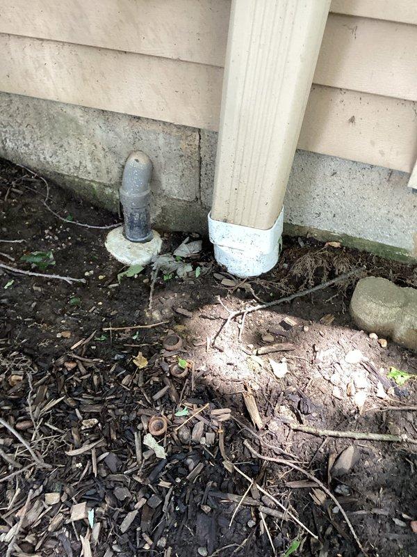 Conducted comprehensive inspection of sump pump system and evaluated moisture intrusion concerns at property located at lowest elevation point. Verified sump pump operational status and identified moisture accumulation on interior foundation walls. Discovered exterior sump discharge line disconnected from downspout drain outlet due to ground settlement. Documented foundation conditions, drainage patterns, and water collection issues around building perimeter. Photographed exterior foundation areas showing mulch displacement, organic debris accumulation, and grade conditions contributing to water pooling. Provided technical recommendations for corrective measures including drainage system improvements, installation of swales for proper water diversion, sump discharge line extensions, and foundation waterproofing solutions to prevent future moisture intrusion and protect structural integrity.