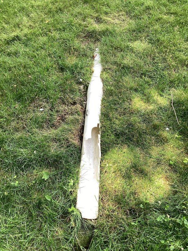 Responded to service call for damaged underground PVC drainage line that had been severed by lawn mower. The affected pipe was part of the downspout discharge system. Excavated trench to expose the damaged section of white PVC pipe, removed the compromised portions, and installed replacement piping to restore proper drainage function. Backfilled trench upon completion of repairs.