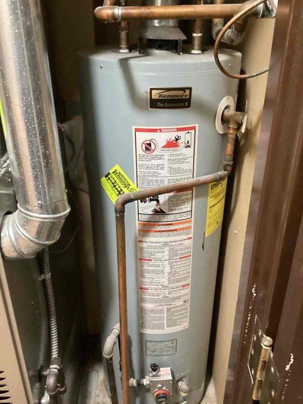 Conducted on-site assessment of existing Kenmore Economizer tanked water heater for replacement estimate. Inspected unit condition, copper supply and discharge piping connections, and surrounding utility space clearances. Documented current installation configuration including proximity to HVAC equipment and available workspace for replacement procedures. Provided estimate for water heater replacement and garbage disposal installation to be scheduled for future service appointment.