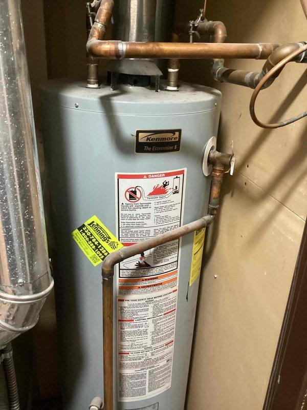 Conducted on-site assessment of existing Kenmore Economizer tanked water heater for replacement estimate. Inspected unit condition, copper supply and discharge piping connections, and surrounding utility space clearances. Documented current installation configuration including proximity to HVAC equipment and available workspace for replacement procedures. Provided estimate for water heater replacement and garbage disposal installation to be scheduled for future service appointment.