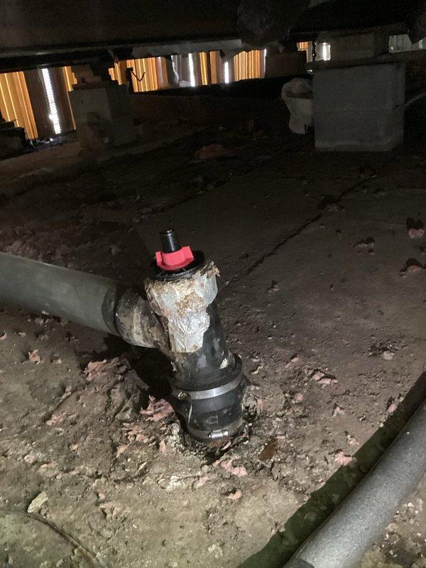 Responded to service call regarding sewer gas infiltration into mobile home caused by loose sewer pipe cap. Upon inspection in crawlspace, found deteriorated cleanout assembly with compromised cap seal on vertical PVC sewer line. Secured and replaced defective cap fitting on cleanout assembly to restore proper seal and prevent sewer gas from entering living space. Verified all connections were properly tightened and system was functioning correctly upon completion.
