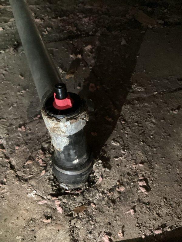 Responded to service call regarding sewer gas infiltration into mobile home caused by loose sewer pipe cap. Upon inspection in crawlspace, found deteriorated cleanout assembly with compromised cap seal on vertical PVC sewer line. Secured and replaced defective cap fitting on cleanout assembly to restore proper seal and prevent sewer gas from entering living space. Verified all connections were properly tightened and system was functioning correctly upon completion.