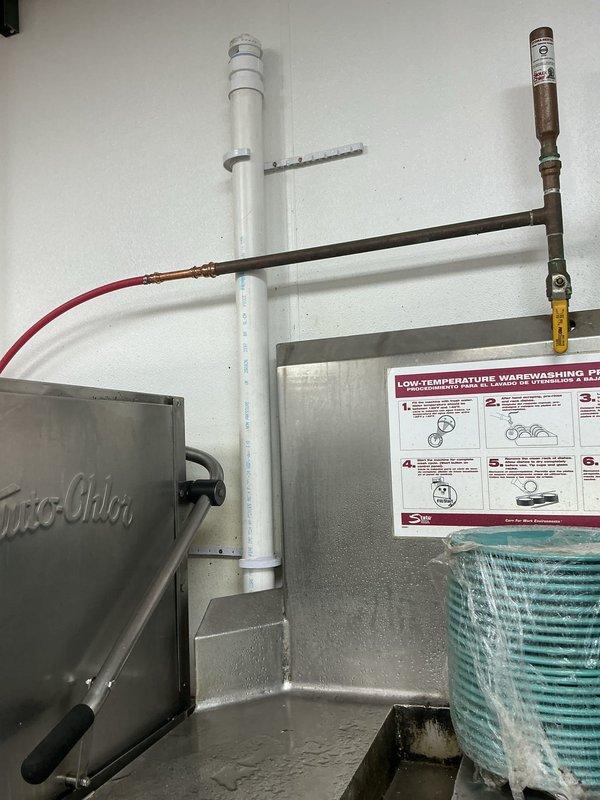 Completed commercial kitchen plumbing installation to support dishwasher and pre-rinse station operations. Repaired pipe within wall cavity and installed under-sink grease trap with proper permitting. Installation included PVC drain line configuration connecting to three-compartment sink system, copper supply line connections with shut-off valves, and integration with existing Scotts-Chill dishwasher equipment. All plumbing work performed to code specifications for commercial food service facility requirements.