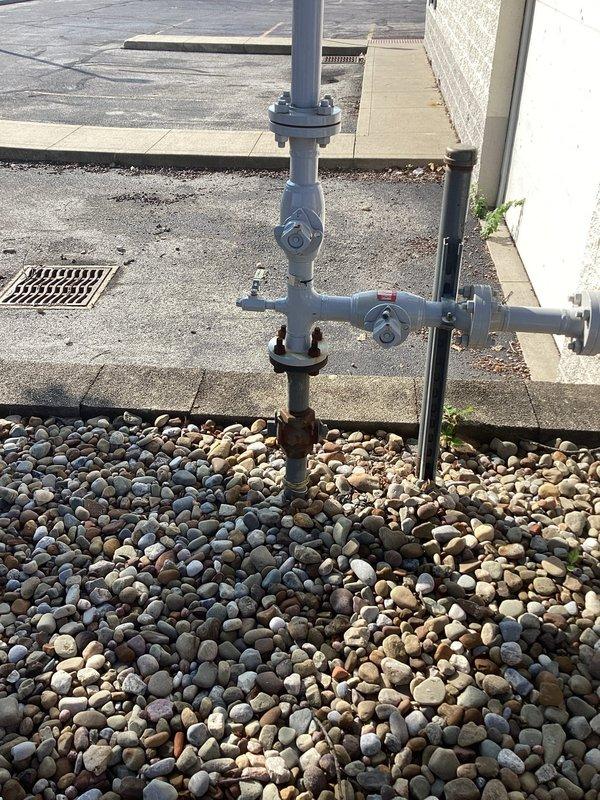 Completed site assessment for relocating hot water plumbing lines from underground to above-ground installation. Documented existing gas meter assembly and exterior utility connections, as well as basement utility room conditions including current pipe routing, concrete block wall structure, and available space for line relocation. Provided photographic documentation of work area to support planning for line rerouting project.