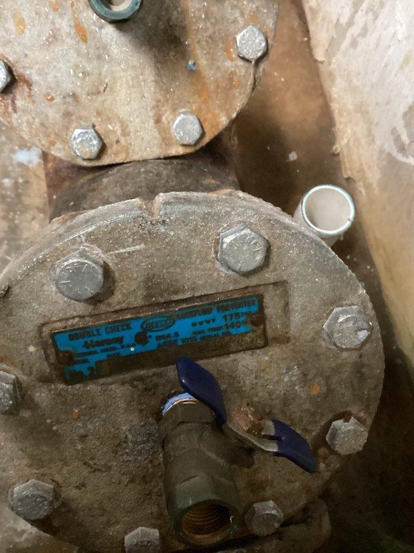 Responded to backflow system issue. Performed inspection of backflow preventer assembly, which showed significant age and corrosion on flanged components and connections. Evaluated condition of device including manufacturer markings and test ports. Documented equipment condition through photographs showing weathered metal surfaces, worn protective coating, and visible rust discoloration on flange bolts and assembly. Test cocks and valve mechanisms were assessed for functionality. System evaluation completed and findings recorded for customer review.