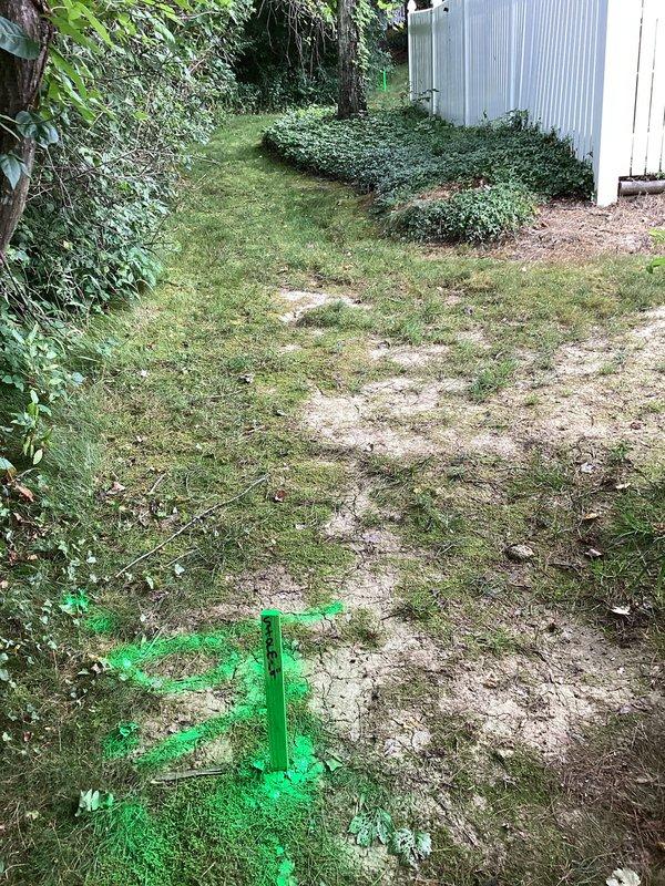 Responded to report of water accumulation and pooling on back patio during rain events. Conducted site assessment of previously installed yard drainage system from last year. Inspected pathway adjacent to property, examined drainage patterns, and verified utility markings in work area. Documented current site conditions including ground surface, vegetation overgrowth affecting drainage flow, and existing drainage infrastructure to determine if additional remediation is required beyond the previous yard drain installation.