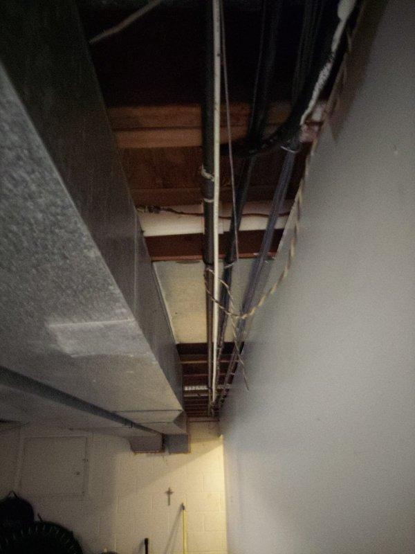 Provided estimate for comprehensive plumbing installation project involving new supply and drain lines for bathroom and kitchen fixtures with connection to existing septic system. Inspected exposed basement ceiling area and documented existing plumbing infrastructure, including PVC drain lines and copper water supply lines secured to floor joists. Assessed routing requirements for new plumbing runs through accessible utility spaces to accommodate planned fixture installations and proper septic tie-in.