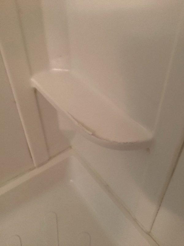 Responded to service call for cracked tub surround in rental property. Upon arrival, inspected fiberglass shower/tub enclosure and confirmed structural damage to the molded surround panels. The crack was located in the corner section where wall panels meet the tub basin. Additionally, noted mold or mildew buildup on the frosted glass shower door near the top center, approximately 3-4 inches in size, indicating moisture intrusion issues. Documented existing conditions with photographs for repair assessment and invoicing purposes. Provided recommendations for tub surround replacement to address the structural compromise and prevent further water damage to surrounding areas.