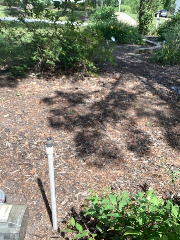 Responded to service call for sprinkler system damage caused by storm drain issues. Upon inspection, identified damaged PVC sprinkler riser and irrigation components in landscaped area with wood chip mulch bedding. Documented existing conditions including affected lawn areas with visible utility markings and compromised sprinkler head assembly. Completed assessment and photographic documentation of damage for repair recommendations.