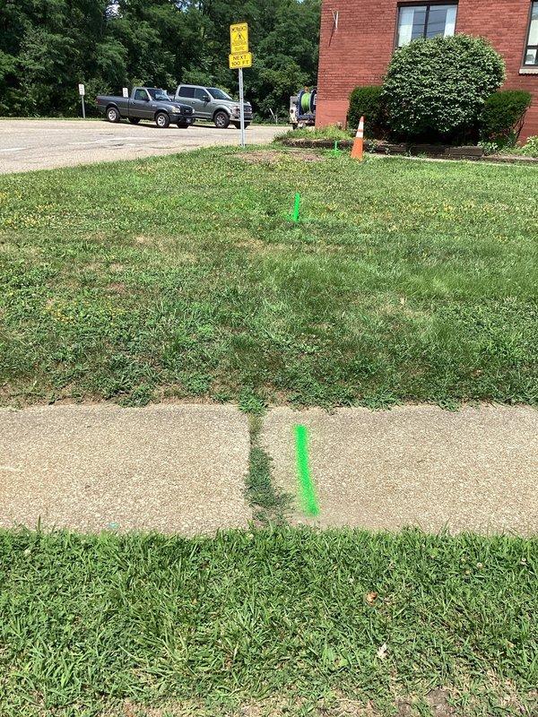 Conducted site assessment and provided estimate for main sewer line replacement at a century-old building experiencing chronic root intrusion issues. The existing main line has been repeatedly compromised by tree root infiltration, requiring a complete line replacement to resolve ongoing blockages and prevent future system failures. Utility locations were marked and documented with photographic evidence of the work area for excavation planning.