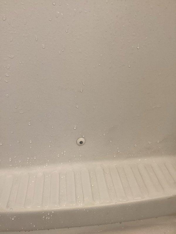 Responded to water leak occurring after showering. Upon inspection, identified moisture accumulation on bathroom walls and shower pan surfaces. Investigated potential leak sources in shower enclosure, examining wall penetrations and fixtures. Documented conditions with photographs showing water droplets on wall surfaces and shower pan, indicating active moisture intrusion. Assessed wall integrity and identified access point for further investigation of plumbing connections behind shower wall to determine source of leak and recommend appropriate repairs.
