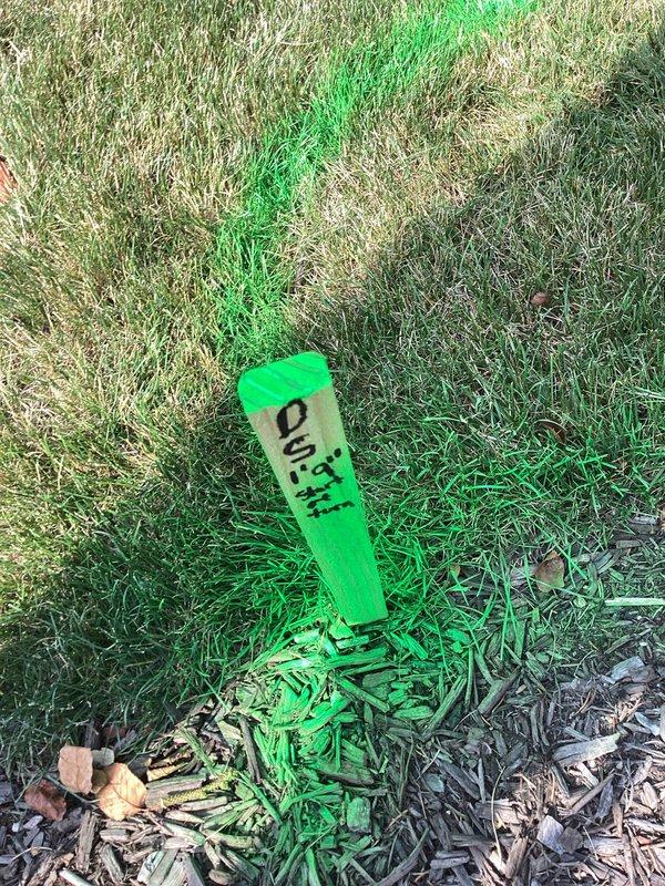 Responded to service call regarding blocked downspout drainage system causing water overflow and mulch displacement onto driveway. Located and marked underground drain line using utility stakes and spray paint to identify cleanout access point. Cleared blockage from main drain line to restore proper water flow and prevent further erosion of landscaping materials.