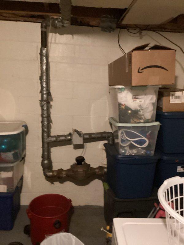 Responded to service call for backflow prevention device assessment. Evaluated existing plumbing configuration in basement utility area, including vertical water supply lines with aged metallic insulation and brass valve assembly. Provided estimate for backflow preventer installation to ensure compliance with local plumbing codes and protect potable water supply from contamination. Documented current plumbing conditions with photographs for customer review and future reference.
