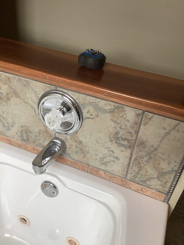 Performed bathtub replacement service, removing existing tub unit and preparing installation area for new bathtub. Took preliminary measurements of the opening to ensure proper fit for replacement unit, and assessed existing plumbing fixtures including chrome shower controls and spout for compatibility with new installation.