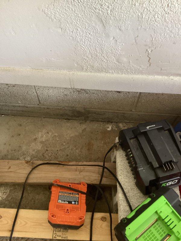Responded to service call for water intrusion into residential basement. Upon inspection, identified significant moisture infiltration evidenced by extensive water damage to ceiling texture, vertical streaking on concrete block walls, and heavy efflorescence deposits throughout the basement perimeter. The primary source was determined to be exterior surface water entering through foundation walls, likely due to improper downspout drainage directing water toward the foundation rather than away from the structure. Documented moisture damage patterns on walls and ceiling, photographed affected areas showing active water staining and mineral deposits consistent with chronic water seepage. Advised customer that downspout extensions and grading improvements are required to redirect surface water away from foundation to prevent continued infiltration.