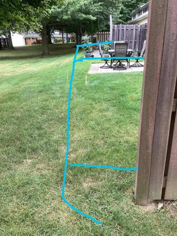 Responded to drainage issue at rear of property where two downspouts were experiencing water backup and overflow at connection points to underground PVC drainage pipes. Upon inspection, found rainwater spewing approximately one foot up from ground level at base connections, causing water discharge onto building siding. Identified affected downspouts (marked as DSPT 1 and DSPT 2) and assessed underground drainage system for blockages or structural failures preventing proper water flow through subsurface piping.