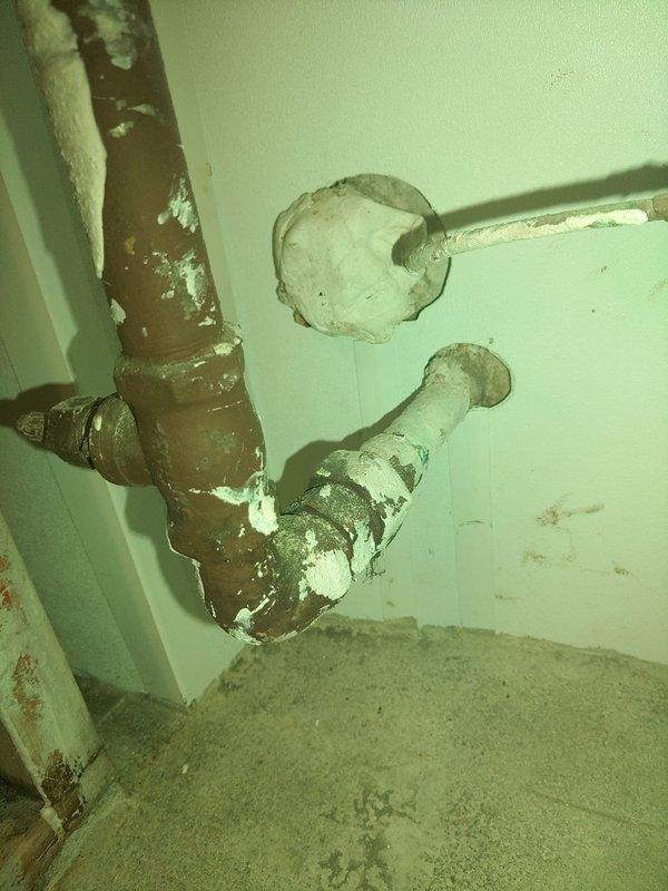 Responded to service call for continuous water accumulation in sump pump pit despite recently installed pump system. Upon arrival, investigated reported water line leak outside residence and potential drainage issues. Inspected existing plumbing infrastructure and identified severely corroded metal piping with extensive rust deterioration and mineral deposit buildup at wall penetrations. Assessed basement area foundation walls and drainage system for possible clogged drain tile or natural spring water intrusion. Documented condition of deteriorated piping system showing significant age-related wear and water damage to surrounding surfaces. Evaluated sump pump installation and confirmed pump operation while investigating source of persistent water flow into collection pit. Recommended further assessment of exterior drain tile system and consideration of pipe replacement due to advanced corrosion state of existing plumbing components.