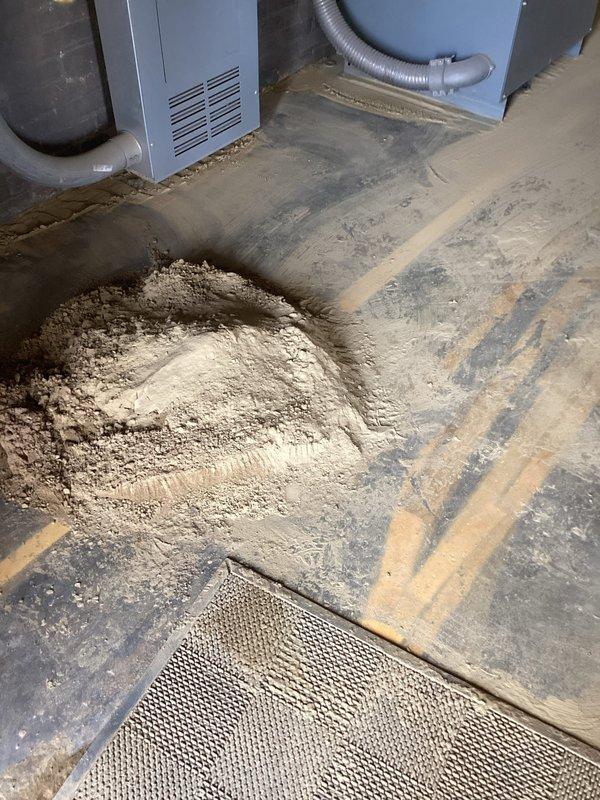 Responded to emergency water service call for suspected underground pipe failure with water supply shut off to property. Upon arrival, conducted thorough inspection of mechanical room and exterior utility areas to locate source of leak. Documented extensive water damage evidence in basement mechanical room, including significant mineral deposits and sediment accumulation on concrete floor near HVAC equipment, indicating prolonged water intrusion. Traced water supply lines and identified blue utility markings on exterior concrete near foundation, suggesting previous excavation work or known utility line location. Assessed damage patterns and determined underground pipe breach as likely cause based on water shutoff necessity and visible evidence. Captured photographic documentation of affected areas for insurance and repair planning purposes. Recommended excavation and pipe replacement services to address underground leak source.