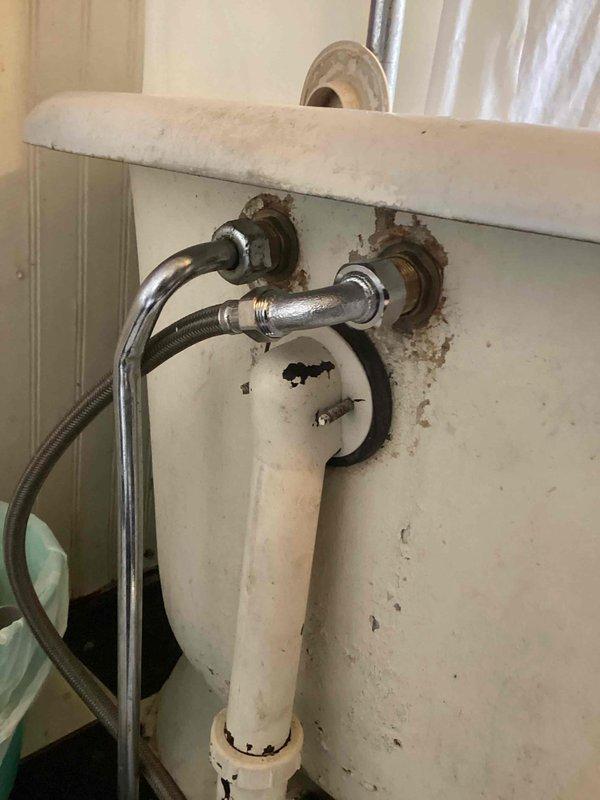 Responded to water leak emergency involving bathtub drain leaking through ceiling into room below. Upon inspection, discovered tub faucet would not shut off completely and no isolation shut-off valves were present at fixture. Documented extensive water damage to ceiling with compromised drywall and exposed cavity, as well as corroded supply valve connections at wall penetrations showing significant rust and deterioration. Photographed damaged areas and plumbing conditions for assessment and repair planning.