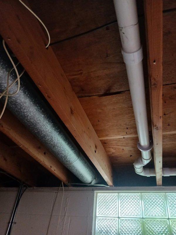 Completed installation of new PVC drainage system in basement utility area as estimated. Installed multiple sections of white PVC waste lines with proper pitch and support, including elbows, T-joints, and straight runs suspended from ceiling joists using appropriate hangers. Work included routing drainage piping to coordinate with existing copper water supply lines, metallic ductwork, and electrical systems in the exposed ceiling cavity. All joints properly fitted and secured to ensure proper drainage flow. Customer approved completed installation and will submit remaining payment by end of month.