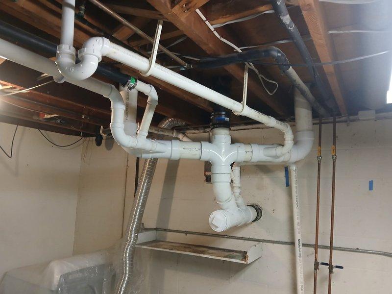 Completed installation of new PVC drainage system in basement utility area as estimated. Installed multiple sections of white PVC waste lines with proper pitch and support, including elbows, T-joints, and straight runs suspended from ceiling joists using appropriate hangers. Work included routing drainage piping to coordinate with existing copper water supply lines, metallic ductwork, and electrical systems in the exposed ceiling cavity. All joints properly fitted and secured to ensure proper drainage flow. Customer approved completed installation and will submit remaining payment by end of month.