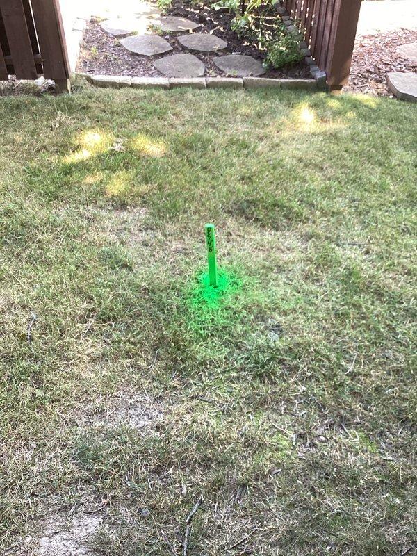 Responded to water pooling issue at garage corner caused by inadequate downspout drainage. Excavated and installed underground drainage system to redirect water away from structure foundation. Resolved erosion problem in mulch bed and eliminated moisture intrusion affecting interior garage wall.