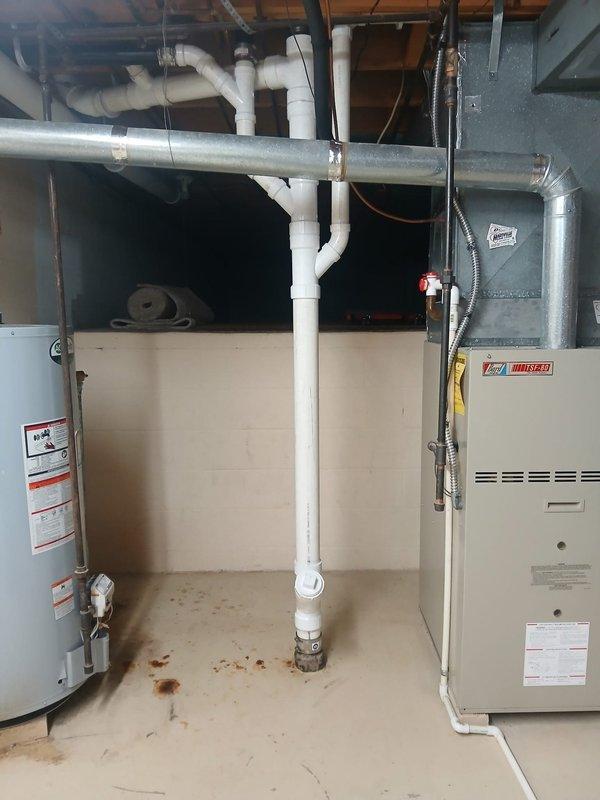 Replaced deteriorated cast iron drain piping in basement with new ABS piping system, connecting to existing cast iron using code-approved banded couplings. Installation included 15 feet of 3-inch pipe, 10 feet of 2-inch pipe, one 3-inch wye cleanout, two 3x2 wyes, one 3x2 cross, one 3-inch closet flange, and miscellaneous 2-inch and 3-inch fittings to complete the drainage system. Additionally, replaced two failed boiler drains within the laundry box to restore proper washing machine hookup functionality. All work completed to code specifications with proper support and alignment of new piping throughout the basement ceiling structure.