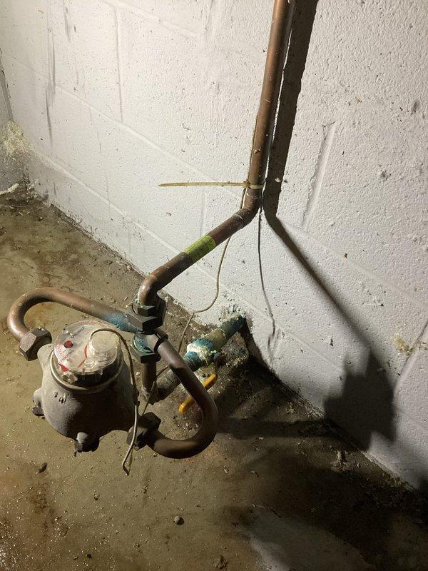 Responded to emergency service call for failed tanked water heater with rupture at top of unit causing flooding in utility area. Upon arrival, found approximately two inches of standing water on floor and complete loss of water supply to property. Assessed water heater showing significant age-related deterioration, including corroded copper piping connections and compromised tank integrity at upper dome section. Documented existing conditions including deteriorated plumbing connections, water meter assembly with visible corrosion and biological growth, and water damage to surrounding concrete surfaces. Coordinated scheduling to accommodate time constraints while ensuring prompt response to restore water service to residence.