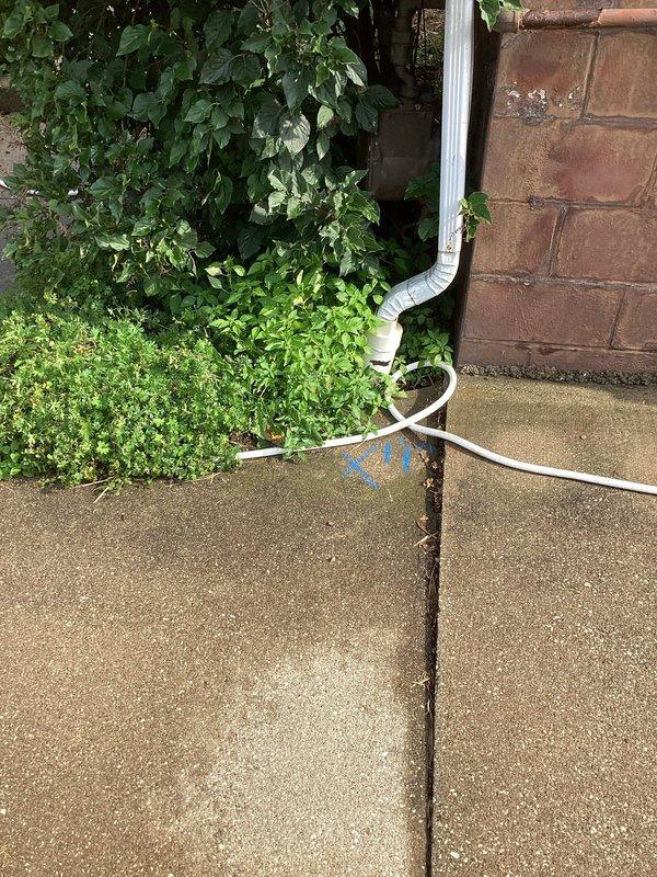 Performed camera inspection of downspout and sump pump drainage system to locate suspected break in underground line. Visual inspection confirmed downspout connection point at foundation and traced drainage path across exterior concrete surface using specialized camera equipment to identify failure point in the system.