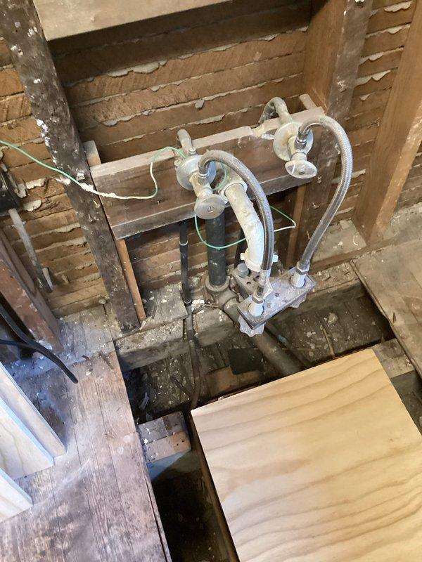 Conducted on-site assessment for complete piping system replacement in residential property with walls removed and floors excavated for access. Evaluated existing water supply lines, drainage piping, and waste lines throughout the structure requiring full replacement. Documented current infrastructure conditions including aged galvanized components, deteriorated piping in attic/ceiling spaces, and compromised mechanical connections. Assessed installation requirements for new stand-up shower fixture integration into updated plumbing system. Photographed existing conditions showing exposed framing, accessible pipe runs, and mechanical equipment locations to inform comprehensive replacement estimate.