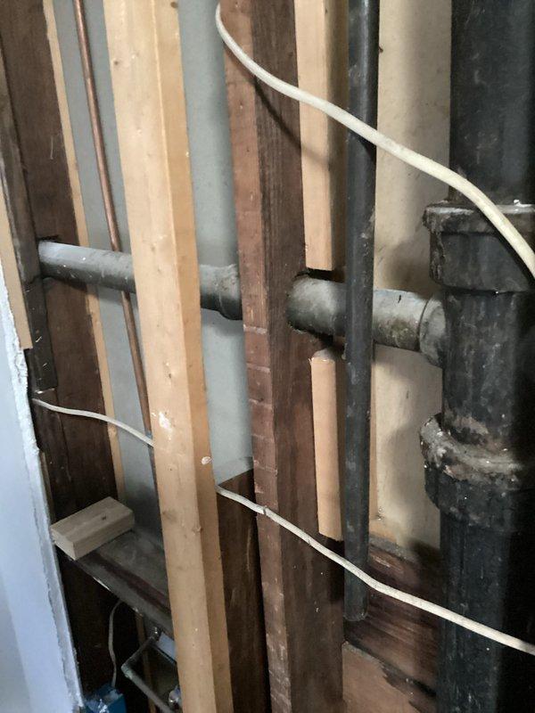 Replaced deteriorated galvanized main drain stack with new black ABS piping system. The existing galvanized stack had reached end of service life and required complete removal and replacement to prevent potential failures. New ABS pipes were properly secured to wooden framing members using approved strapping and brackets, ensuring code-compliant installation throughout the plumbing chase.