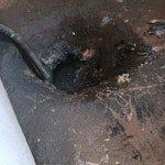 Responded to main line backup affecting the drainage system. Located and accessed the main drain cleanout on exterior paved surface. Performed thorough cable augering of the main sewer line to clear blockage and restore proper flow. Verified clearance by running water through the system and confirming drainage was functioning normally. Left cleanout accessible and work area clear of debris.