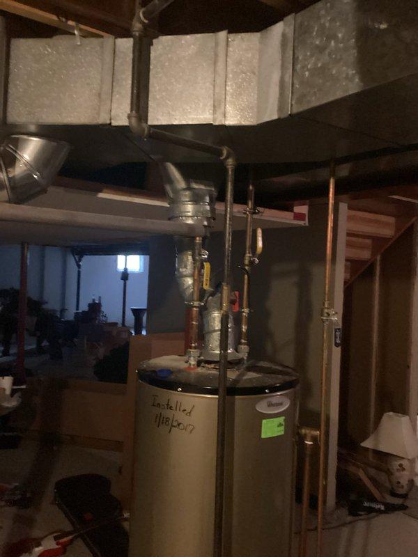 Completed installation of customer-supplied tankless water heater unit in basement mechanical room, replacing existing conventional tank water heater. Reconfigured and repositioned existing copper supply and return lines to accommodate new tankless unit mounting location and connection points. Verified all plumbing connections, tested system operation, and ensured proper venting and combustion air requirements were met for safe operation of the new tankless water heating system.