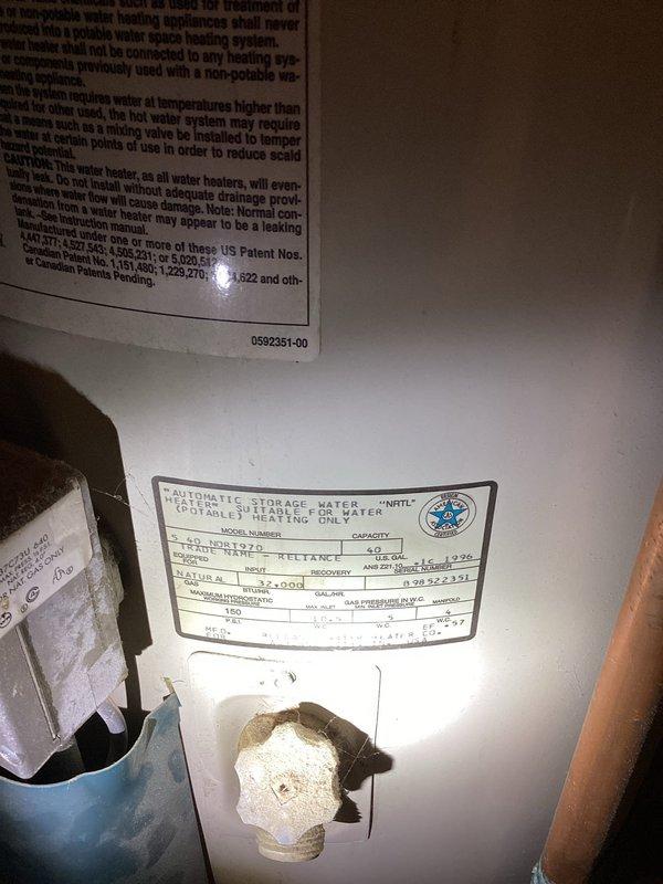 Conducted on-site evaluation of natural gas tanked water heater to provide replacement estimate. Unit assessed showed significant age-related deterioration including heavy dust and sediment accumulation on top panel, tarnished copper piping connections, and general wear throughout the system. Documented existing water heater specifications, model information, and current plumbing configuration including pressure relief valve, inlet/outlet connections, and venting system. Photographed unit condition and technical specification labels for accurate replacement sizing and equipment recommendations.