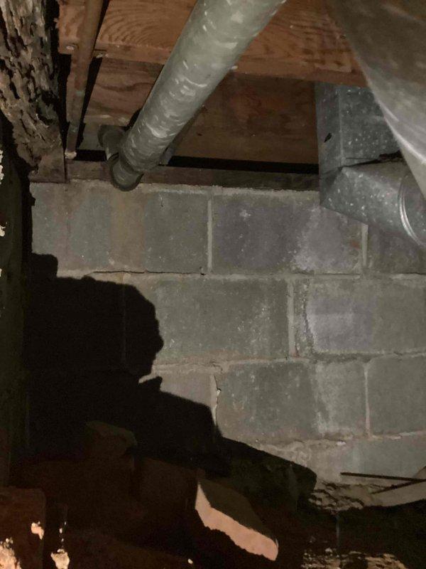 Replaced deteriorated kitchen drain pipe and rerouted drainage system into existing PVC infrastructure in crawl space. Installation included new white PVC piping with proper support brackets mounted to concrete block wall, ensuring code-compliant slope and secure connections to pre-existing drainage system.