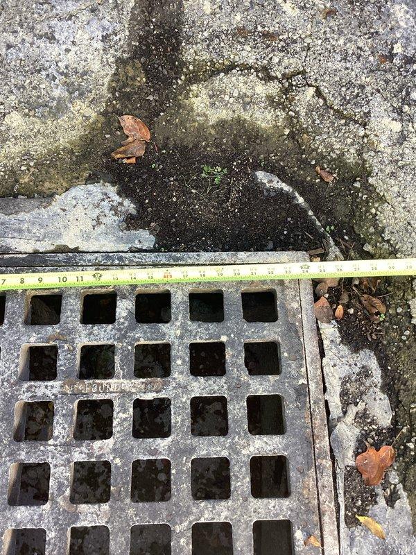 Completed on-site assessment of existing catch basin in driveway requiring replacement. The drainage grate showed significant weathering and corrosion from prolonged exposure to elements. Surrounding concrete and asphalt surfaces displayed extensive deterioration including multiple radiating cracks, surface wear, and organic growth accumulation. Documented current conditions with measurements and photographs for estimate preparation. Quote to be provided via email for complete catch basin replacement including removal of existing deteriorated unit and installation of new drainage system.
