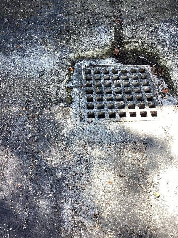 Completed on-site assessment of existing catch basin in driveway requiring replacement. The drainage grate showed significant weathering and corrosion from prolonged exposure to elements. Surrounding concrete and asphalt surfaces displayed extensive deterioration including multiple radiating cracks, surface wear, and organic growth accumulation. Documented current conditions with measurements and photographs for estimate preparation. Quote to be provided via email for complete catch basin replacement including removal of existing deteriorated unit and installation of new drainage system.