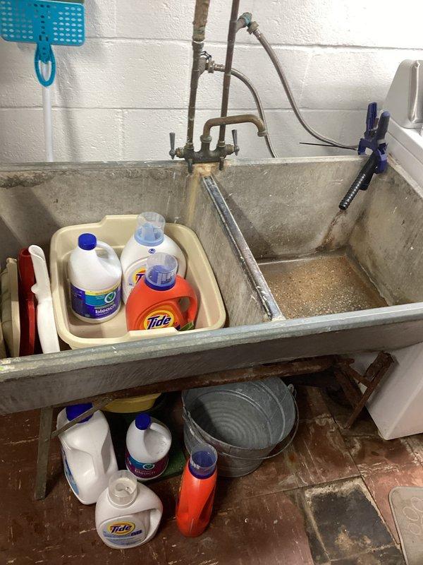Responded to utility sink repair request where concrete utility tub leg had detached from wall mounting. Upon assessment, evaluated existing plumbing configuration including copper supply lines and drain connections to determine feasibility of converting to double bay sink installation as requested. Examined washer drain routing options to floor drain as temporary solution while permanent fixture replacement is planned. Documented current condition of utility sink area, plumbing connections, and surrounding workspace to provide accurate scope for future installation work.